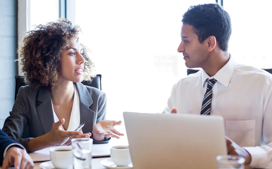 man and woman talking at a desk